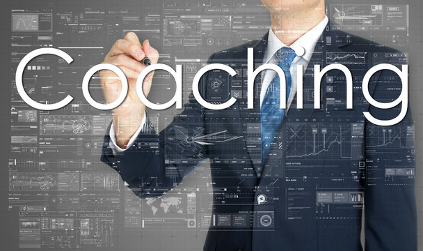 the businessman is writing Coaching on the transparent board wit