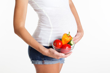 Belly of pregnant girl with vegetables