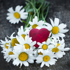 Obraz premium Beautiful fresh daisies decorated with hearts on wooden texture