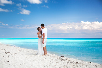 Newlyweds in love on white sandy beach