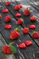 Strawberries and candy on wooden table