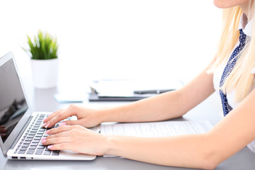 Fototapeta premium Close up of business woman hands typing on laptop computer, blue tie with polka dots