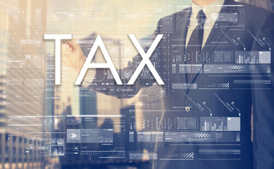 businessman writes on board text: TAX - with sunset over the cit