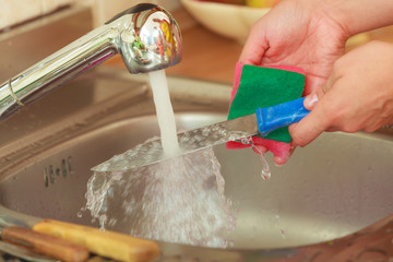 Woman doing the washing up in kitchen