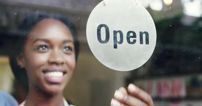 Small business owner turning over open sign