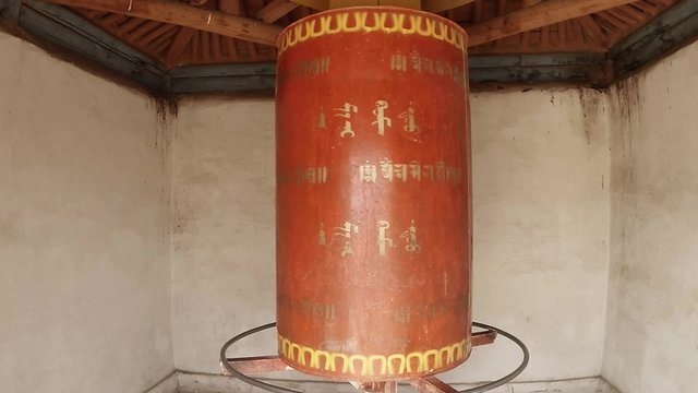
ancient Buddhist prayer wheel slowly reel spinning mantras in Sanskrit inscriptions Erdene Zuu Buddhist monastery - one of the oldest monuments of Mongolia