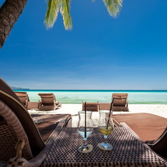 Two glasses with finished up cocktails on tropical beach