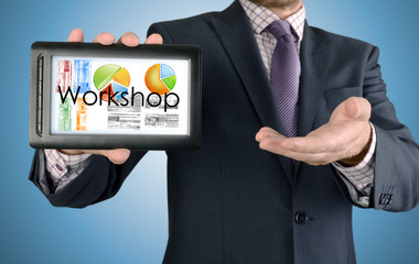 Businessman showing business concept on tablet - Workshop