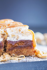 Apple Cake with hazelnuts caramel topping cinnamon and sugar powder on the black tray