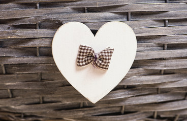 Wooden heart with a loop of fabric on a basket decorated with a wooden heart