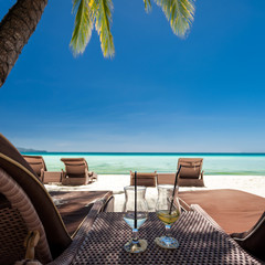 Two glasses with finished up cocktails on tropical beach