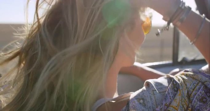 beautiful blonde friend enjoying road trip in vintage convertible car