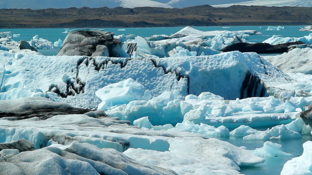 Icebergs float in a vast blue glacier lagoon in the interior of Iceland.