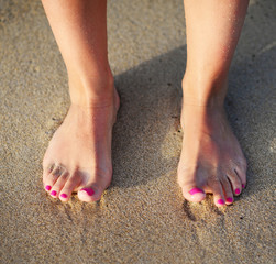 Beach travel - woman walking on sand beach leaving footprints in