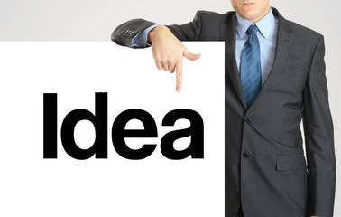 Businessman holding or showing banner with text Idea