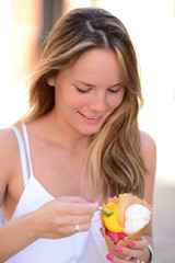 Portrait of young happy woman eating ice-cream outdoor