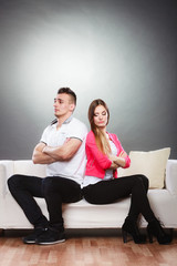 Fototapeta na wymiar Young couple after quarrel sitting on sofa back to back