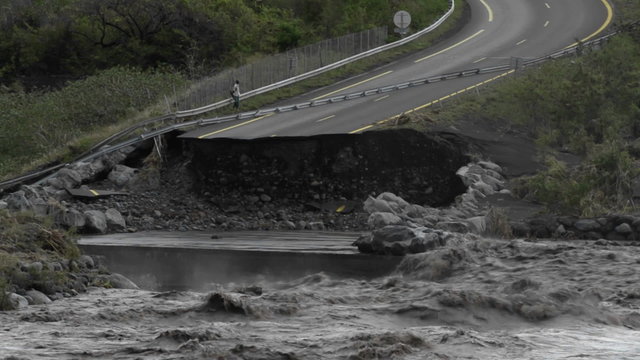 A flood washes away a highway.