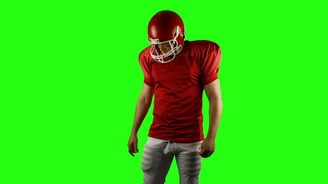 Red serious american football player posing