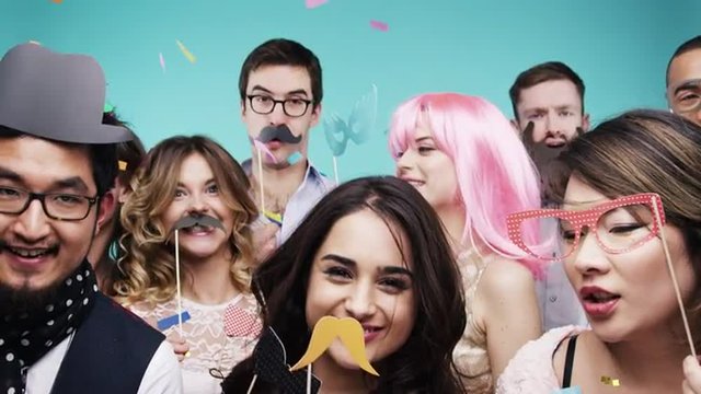 Multi racial group of funny people celebrating slow motion party photo booth 