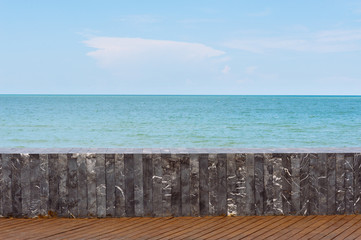 Stone tile wall on sea and sky background