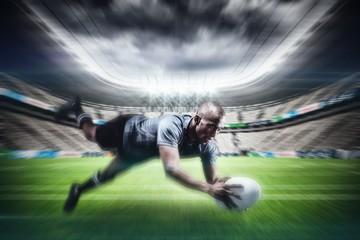 Obraz na płótnie Canvas Composite image of sportsman jumping for catching rugby ball