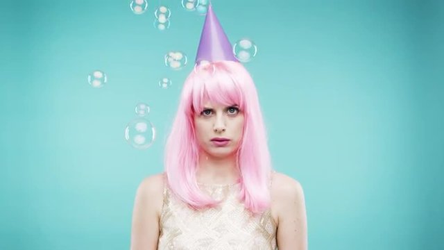 Crazy face pink hair woman dancing in bubble shower slow motion photo booth blue background
