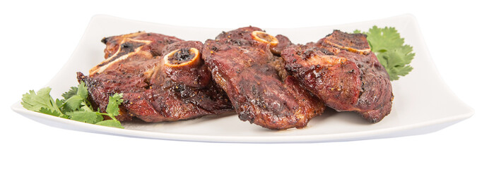 Roasted pieces of lamb on white plate over white background