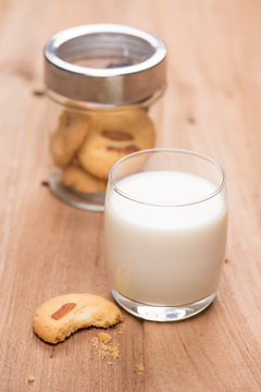 cup of milk wite cookies on wood table