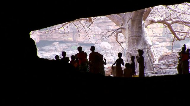 Children stand silhouetted in a cave in Mali, Africa.