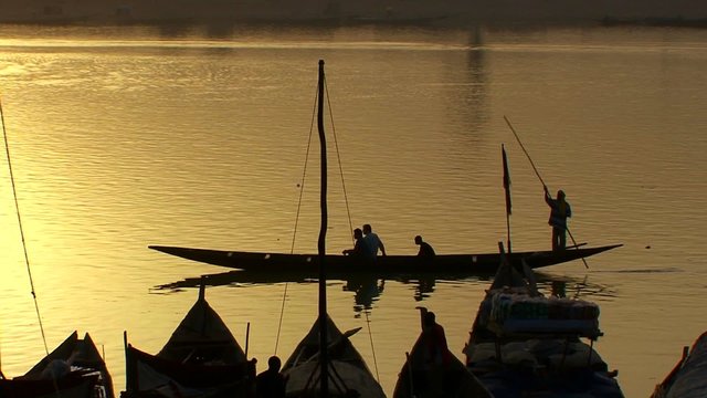 Boats are rowed on the Niger River in beautiful golden light in Mali, Africa.