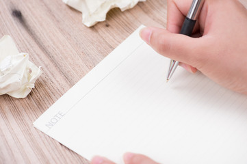 Closeup of woman's hand writing on paper