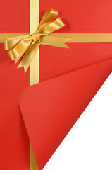 Gold gift bow and ribbon for christmas or birthday present being opened unwrapped red wrapping...