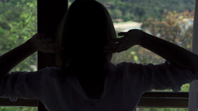 Woman stretching her arms by window, slow motion 240fps