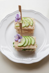Homemade chicken cucumber cream cheese sandwiches with purple flo