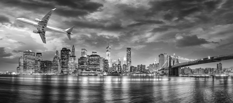 Fototapeta Black and white view of airplane overflying New York City