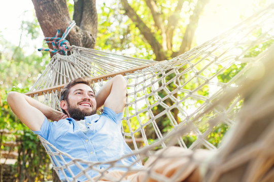 caucasian man using mobile phone white swinging in a hammock