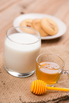 glass of milk with honey and cookie