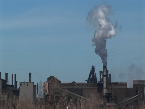 A small industrial plant spews out smoke.
