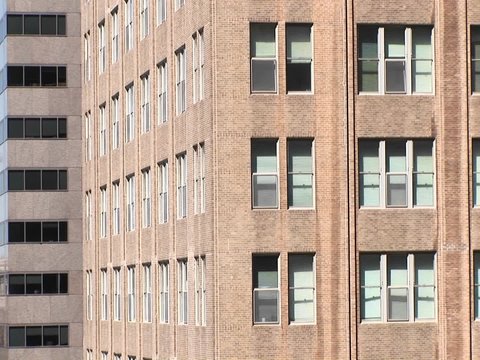 The camera zooms in to a close look at two windows in a large building.