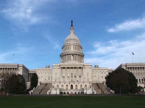 From a long-shot of the eastern facade of the U.S. Capitol building in Washington, DC, the camera zooms in on the building's landmark rotunda and unique iron dome.
