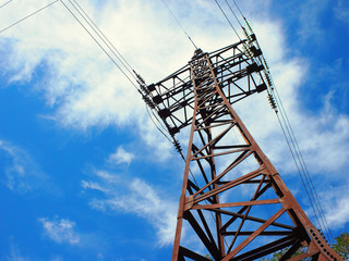 Upward view diagonally to the power line and pylon