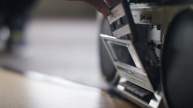 4K Close up of a female hand putting a music cassette into a retro stereo player and pressing play, shot on Red Epic Dragon