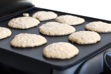 Oat pancakes cooking on electric barbecue