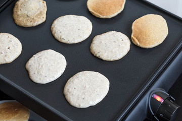 Fototapeta na wymiar Oat pancakes cooking on electric barbecue