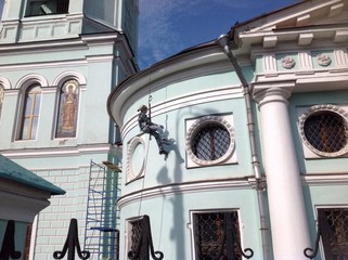 штукатур работает на стене церкви
