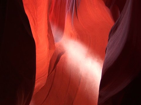 Medium-shot of a Light beam shooting through Antelope Canyon in Arizona.