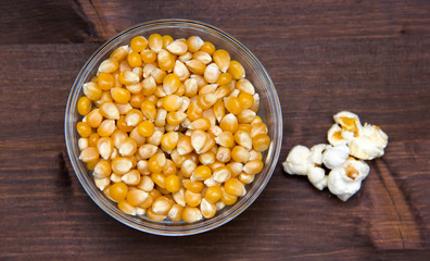 Maize grain dried with popcorn beside on wooden table seen from above