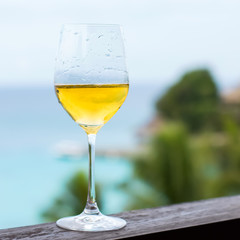 Glass of white wine on balcony rail