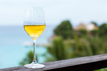 Glass of white wine on balcony rail